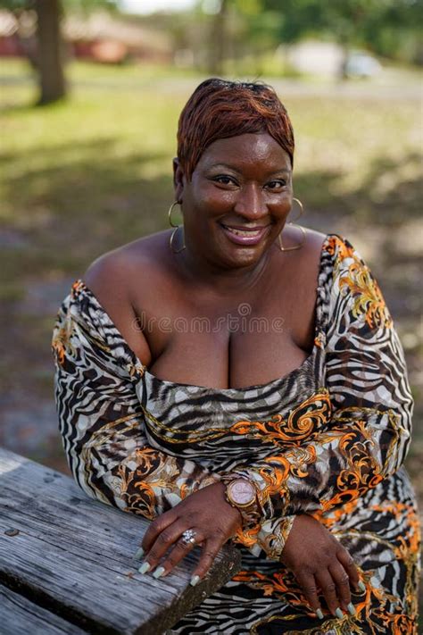 Bbw Big Black Beautiful Model Sitting On A Park Bench Outdoors Stock