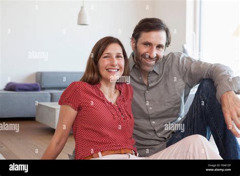 Mature Couple Sitting On Floor Of Living Room Stock Photo Alamy