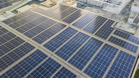 Aerial View Of A Solar Panel Photovoltaic With Reflection On Building