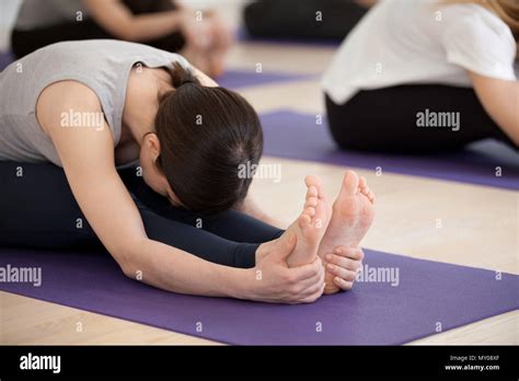 Group Of Young Sporty People Practicing Yoga Lesson Doing Seated