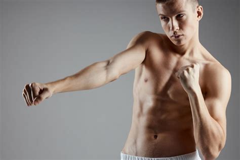 Premium Photo Boxer With A Naked Torso Training On A Gray Background Abs Cubes On The Stomach