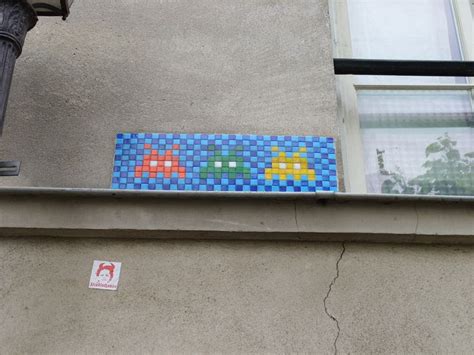 A Blue And Yellow Mosaic Tile On The Side Of A Building Next To A Lamp Post