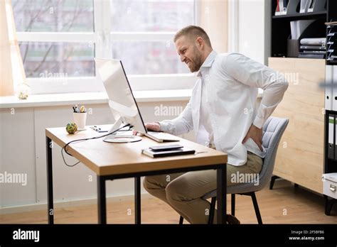 Bad Posture Sitting At Office Desk Using Computer Stock Photo - Alamy