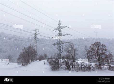 High Voltage Transmission Line And Electricity Pylon In Winter On A