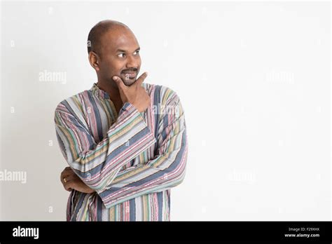 Portrait Of Confident Mature Casual Indian Man Having A Thought Looking At Side Copy Space