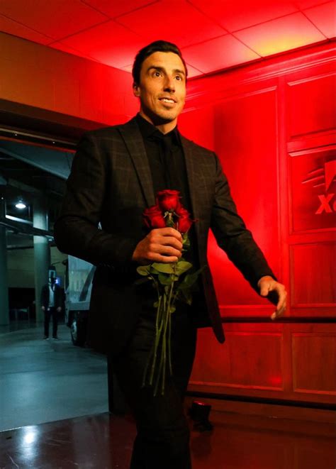 A Man In A Suit And Tie Holding A Rose