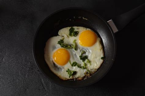 Premium Photo Two Fried Eggs In Cast Iron Frying Pan