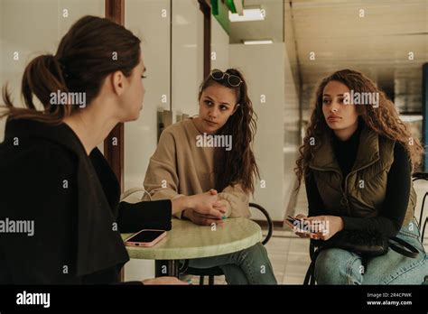 Side View Shot Of Lovely Brunette Girl With Sunglasses On Her Head Holding Her Friend Hand While