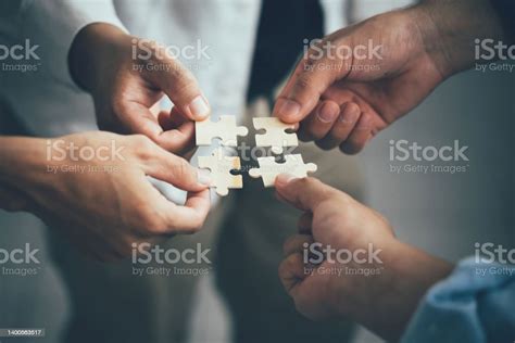 Concept Of Teamwork And Partnership Hands Join Puzzle Pieces In The