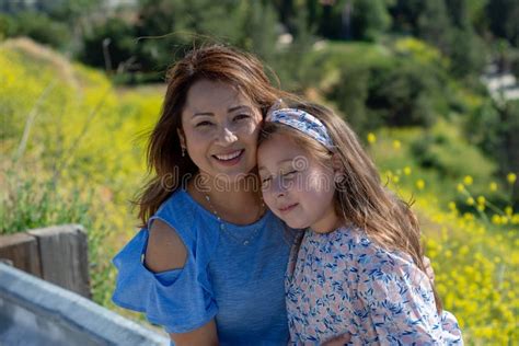 Madre E Hija De Latina Que Sonr En Y Que R En En Una Colina Delante De Las Flores Amarillas