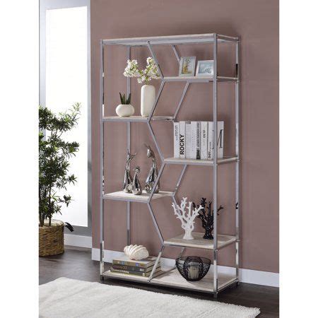 A Metal Shelf With Books And Vases On It Next To A Rug In Front Of A Window