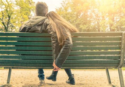 Couple On A Bench Two Lovers Sitting On A Bench In A Park And Holding