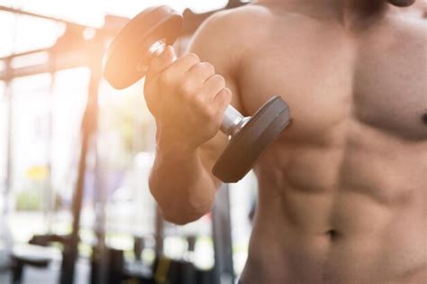 Premium Photo Midsection Of Shirtless Man Lifting Dumbbell At Gym