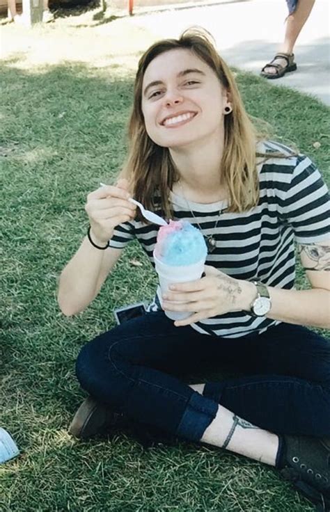 A Woman Sitting On The Grass Eating An Ice Cream