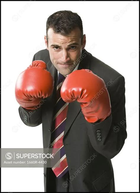 Portrait Of A Businessman Wearing Boxing Gloves SuperStock