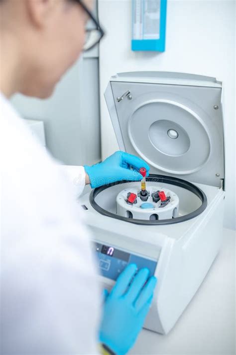 Technician In Blue Gloves Putting The Test Tube To Centrifuge Stock