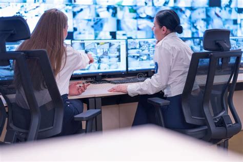 Security Guard Monitoring Modern Cctv Cameras In Surveillance Room Two