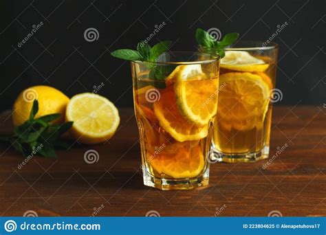 Two Glasses With Traditional Iced Tea With Lemon And Mint Leaves In