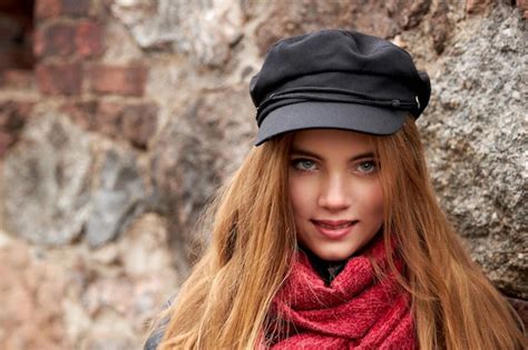 Chica Con Una Gorra Negra Y Una Bufanda Roja Contra Una Pared De