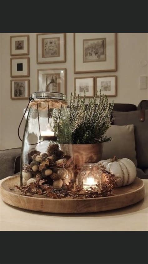 A Table Topped With A Glass Vase Filled With Plants And Rocks On Top Of