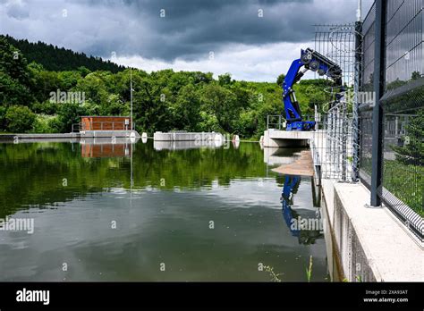 Small hydroelectric dam operates in a forested area, exemplifying ...