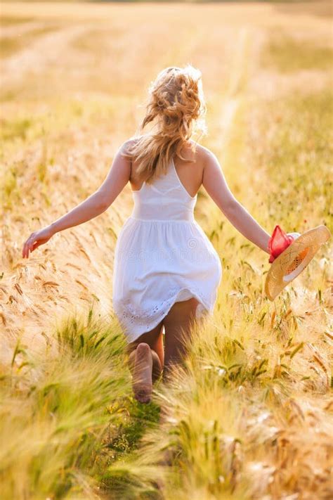 Jeune Fille Blonde Heureuse Dans La Robe Blanche Avec Du Th Courant De Chapeau De Paille Photo