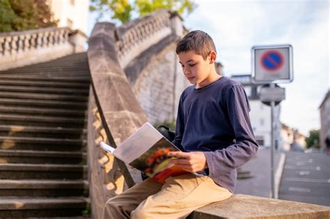 Premium Photo | Boy involved in reading a book outdoors