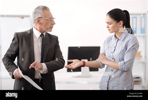 Serious Brunette Stretching Her Arm To Colleague Stock Photo Alamy