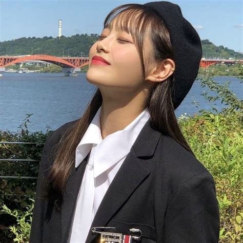 A Woman In Uniform Looking Up At The Sky With A Bridge In The Distance