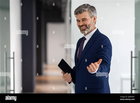 Handsome Middle Aged Businessman In Suit Making Inviting Gesture