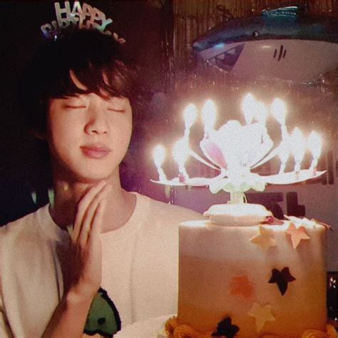 A Woman Standing In Front Of A Cake With Candles On It