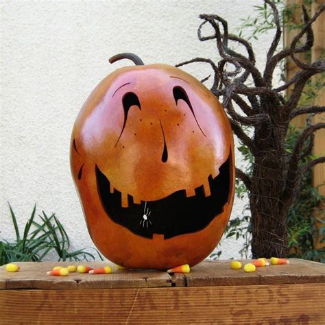 A Carved Pumpkin Sitting On Top Of A Wooden Box With Candy In Its Mouth