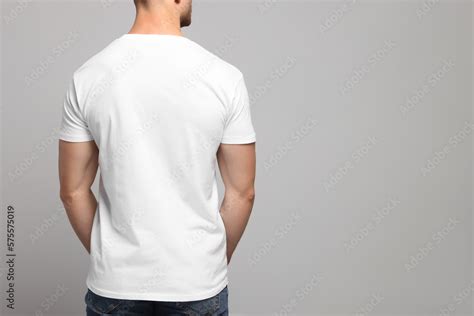 Man Wearing White T Shirt On Light Grey Background Back View Mockup