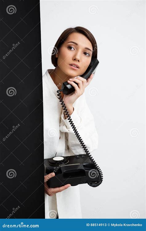 Menina Que Fala No Telefone Velho Sobre O Fundo Preto E Branco Imagem