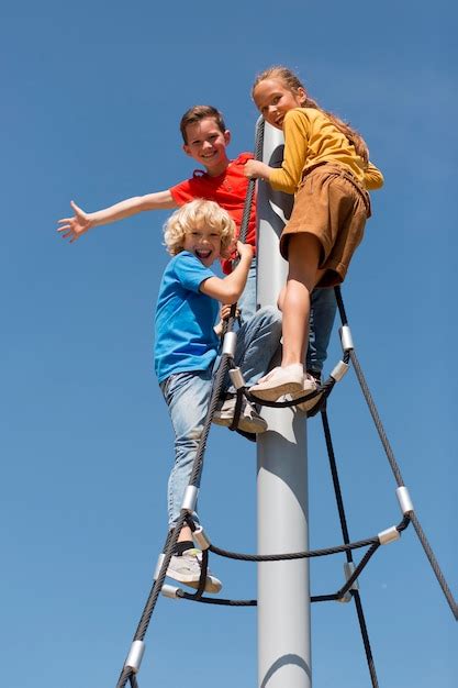 Free Photo | Full shot kids climbing rope outdoors