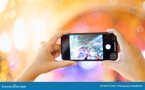 Mano De Niña Sosteniendo Un Teléfono Móvil Tomando El Túnel De Luz