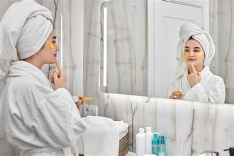 Beautiful Woman With Eye Patches In White Bathrobes In Bathroom Stock