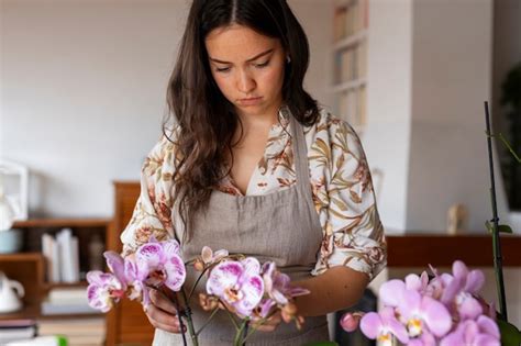 Eine Frau Schm Ckt Ihr Haus Mit Orchideen Kostenlose Foto