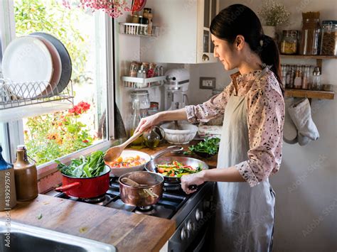 Woman cooking lunch in a kitchen Stock Photo | Adobe Stock