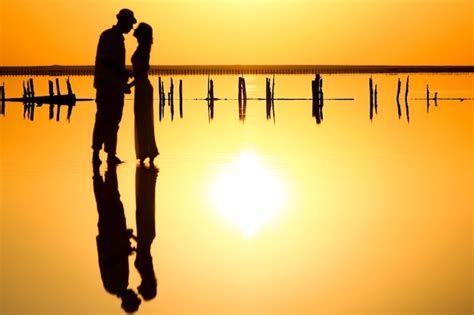 Una Pareja Feliz En El Mar Con Fondo De Silueta De Reflejo De Agua