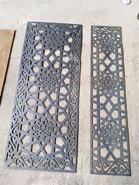 Two Metal Grates Sitting On The Ground Next To Each Other With Holes In