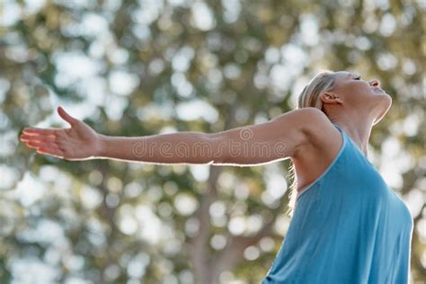 Greet The World With Peace Everyday A Mature And Fit Woman Standing Outside In Nature With Her