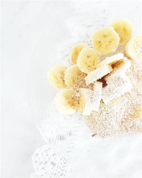 Sliced Bananas And Powdered Sugar In A Glass Bowl On A White Tablecloth