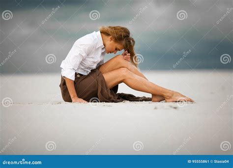 Young Sad And Pensive Woman Sits On Sand In Desert Stock Image Image