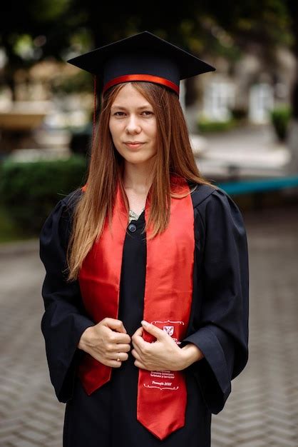 Premium Photo A Woman In A Graduation Cap And Gown Is Wearing A Red