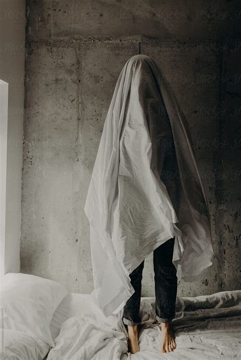 "A Sad Ghost Standing Alone On A Messy Bed In A Cement Loft Bedroom" by Stocksy Contributor ...