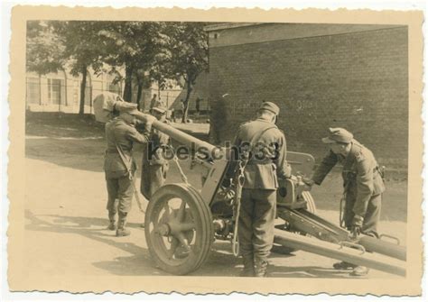 Foto Panzerjäger der Wehrmacht mit Feldmützen an einem 7 5cm Pa K