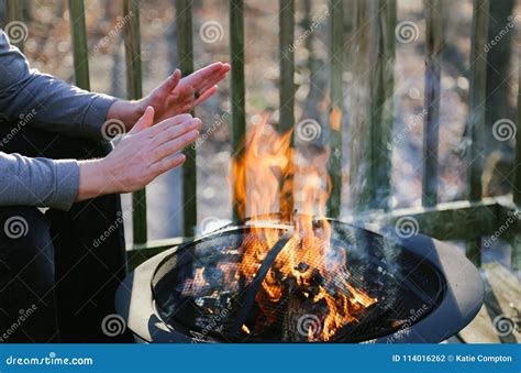 Man Warms His Hands Over A Fire Pit On A Deck Stock Photo Image Of