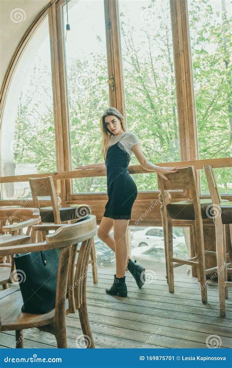 Beautiful Elegant Brunette Girl Wearing A Black Dress Is Relaxing In A Street Cafe Advertising