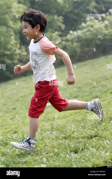 Boy playing football in field Stock Photo - Alamy